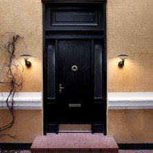 Detalle de las pantallas metálicas del aplique PH 3-2½ iluminando pared de piedra