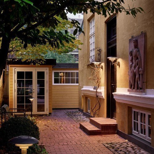 Aplique exterior PH 3-2½ encendido al anochecer sobre entrada principal