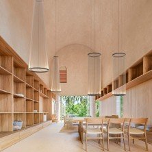 Lámpara Array 1860 instalada en comedor con techos altos y mobiliario de madera clara