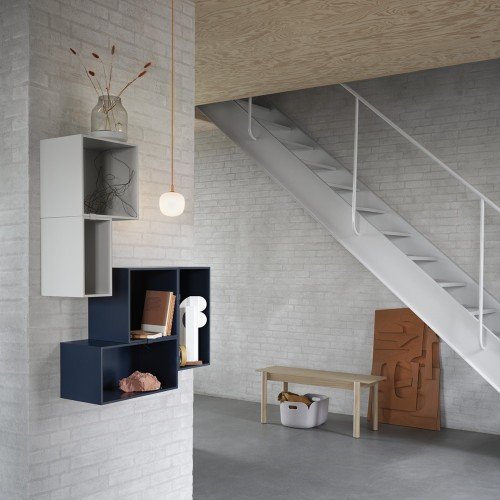 Rime pendant lamp 12 cm con cable ocre suspendida en hueco de escalera junto a estanterías modulares.