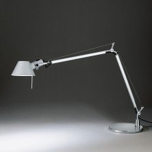 Tolomeo table body en acabado aluminio, brazo articulado extendido sobre fondo oscuro. Lámpara de sobremesa Tolomeo – Artemide