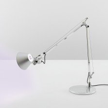 Tolomeo LED Pure Integralis en aluminio, brazo articulado extendido sobre mesa blanca, vista lateral Lámpara de sobremesa Tolomeo LED Pure Integralis – Artemide