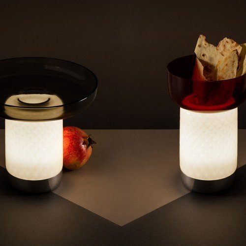 Dos Bontà encendidas sobre mesa, combinando plato y cuenco de vidrio. Dos Bontà encendidas sobre mesa, combinando plato y cuenco de vidrio.