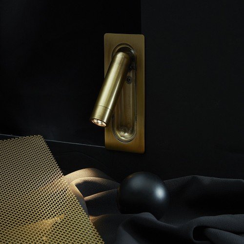 Aplique LEDtube Mini Marset latón cepillado iluminando superficie con luz cálida